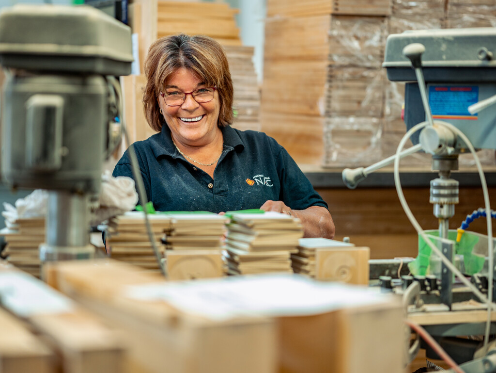 Woman smiling while building drawers at NAC - Your career at NAC